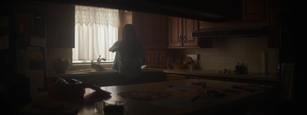 A woman looks out the window in the kitchen