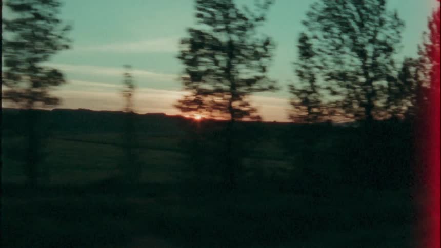 Sun going down seen from car driving on country road