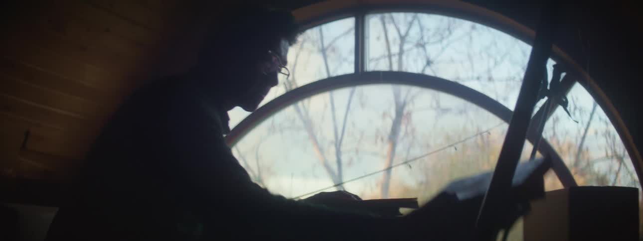 A young white man is going through his belongings inside of his house
