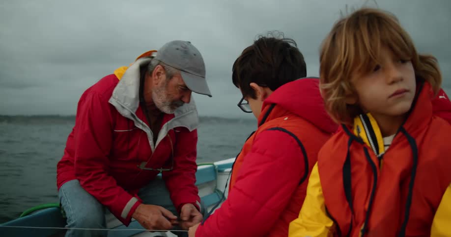 Family wearing bright red jackets sitting on a boat on a fishing trip