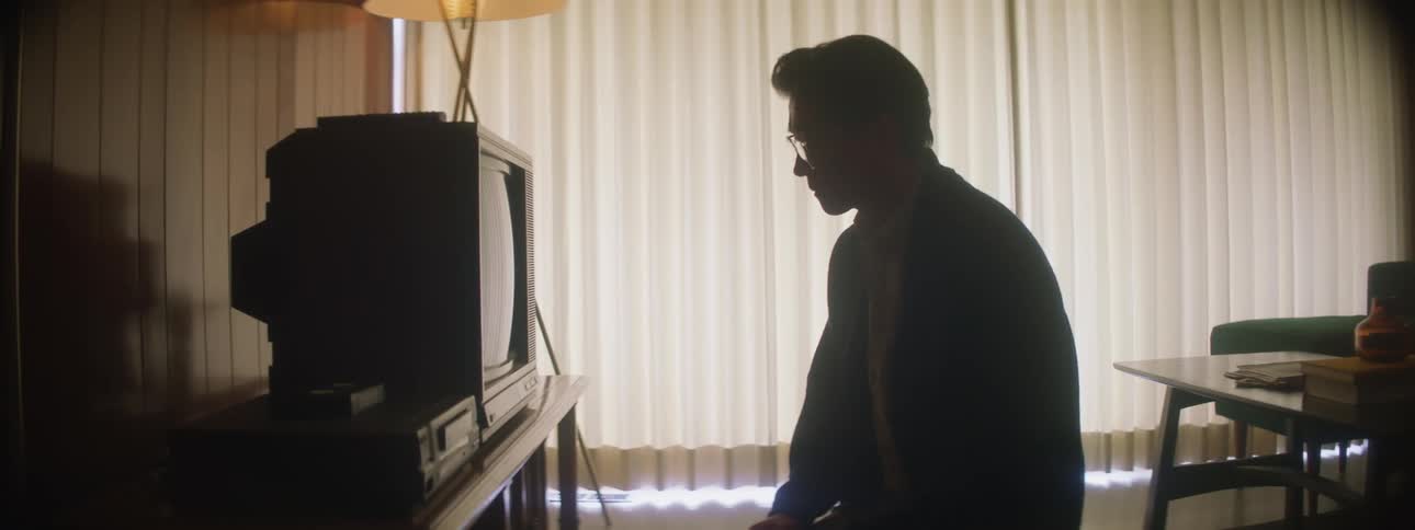 A man sits on the floor inches from his television
