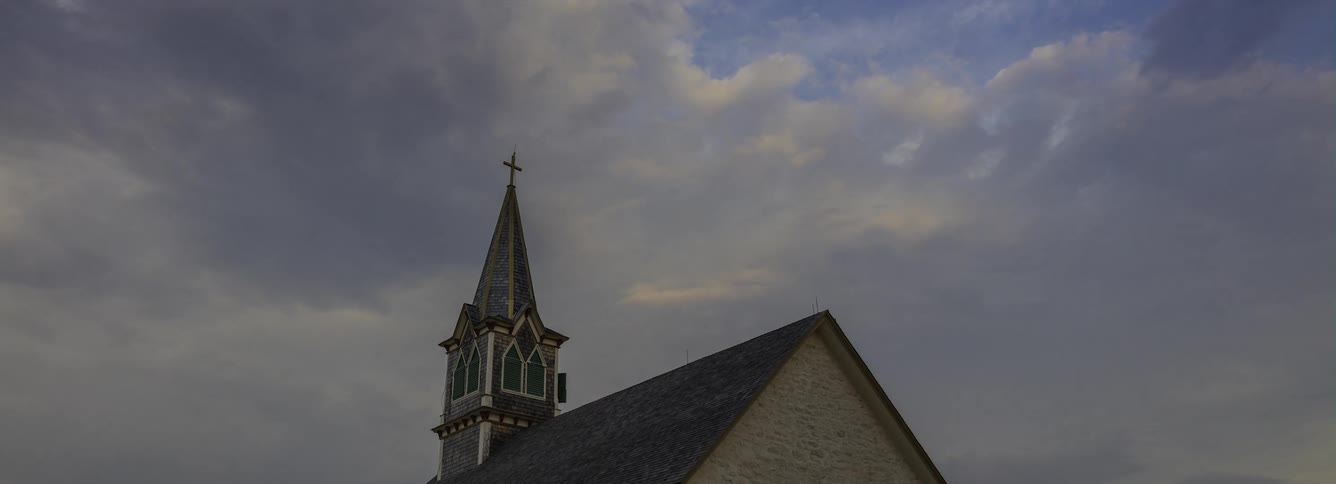 Exterior view of the steeple of church against the cloudy sky