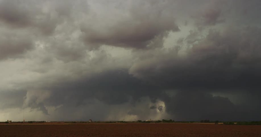 Dark storm clouds are moving over a rural area