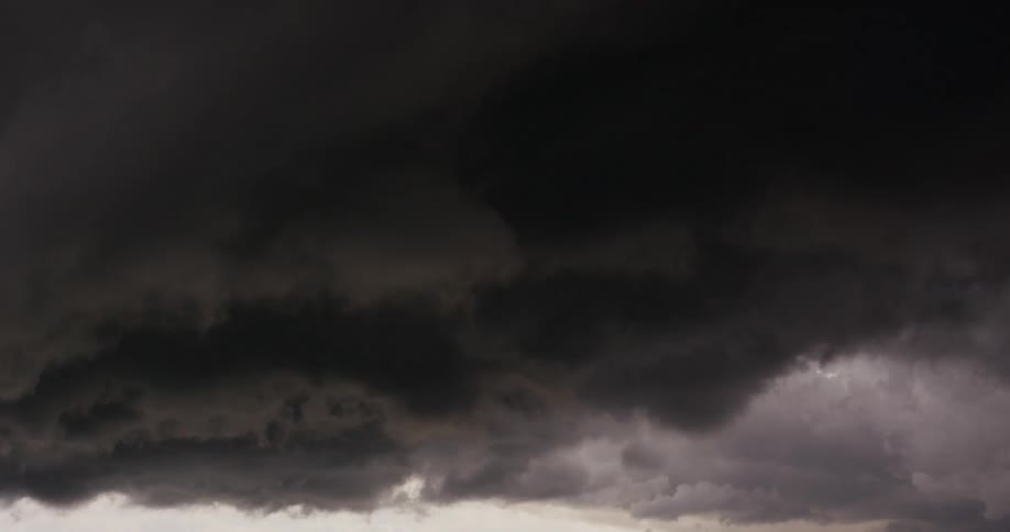 Lightning flashes illuminate dark storm clouds as they move across the sky