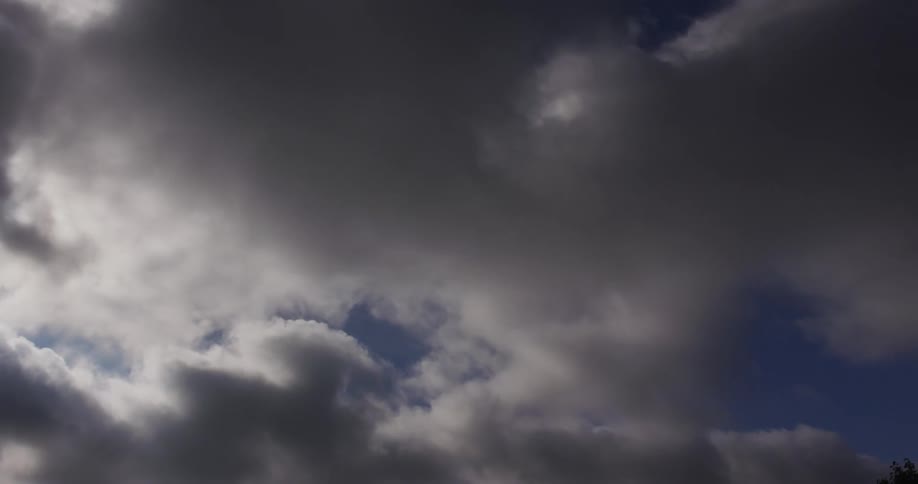 Peaceful scene of clouds rolling under a deep blue sky