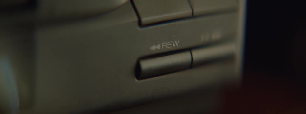 Close up of the finger of a person pressing the rewind button on a cd player