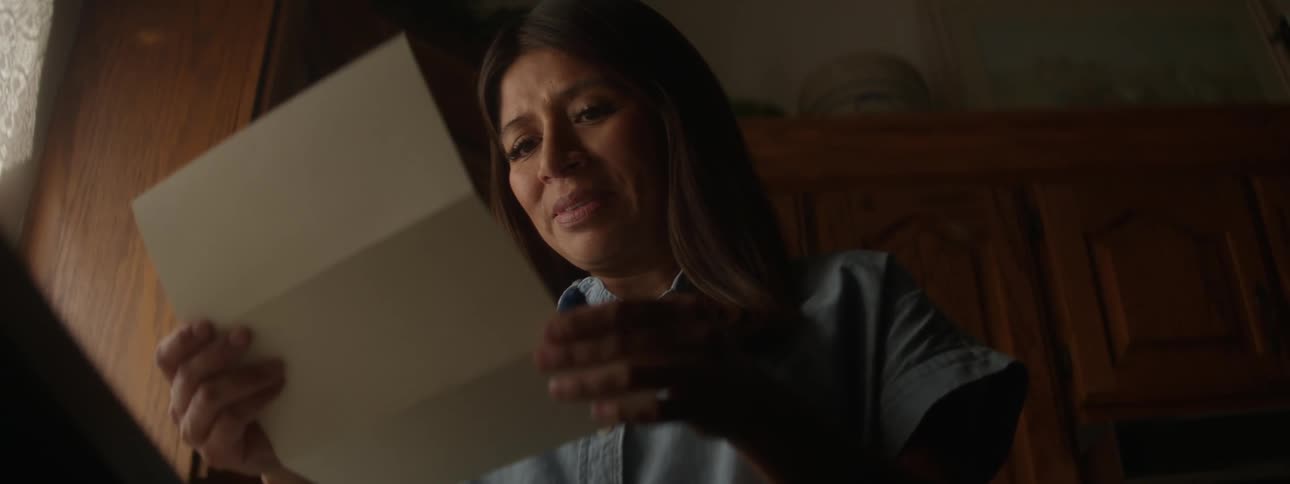A woman cries while reading a letter