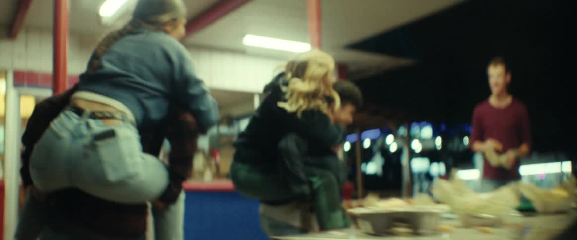Two couples piggybacking in front of a restaurant