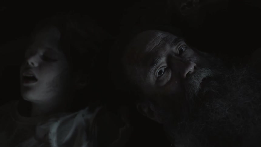 Two bodies are laying in a dark area
