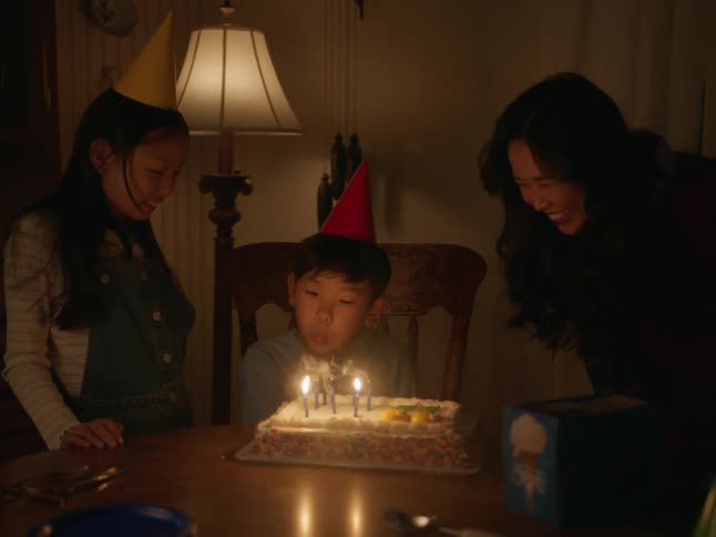 A boy blows out the candles on his birthday cake