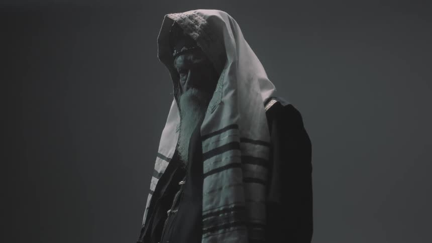 A bearded man with a cloth over his head