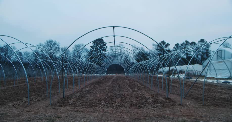 Bare metal arches for greenhouses on the fields of a farm at fall