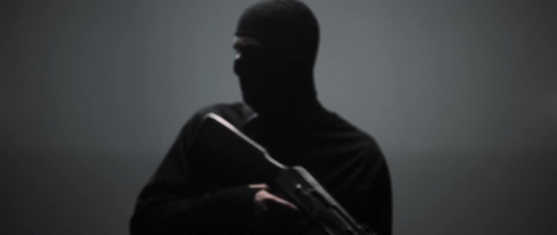 A man in black holds a gun