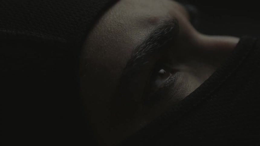 A person wearing a face mask slowly opens their eyes