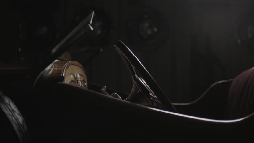 An antique car in a dim garage