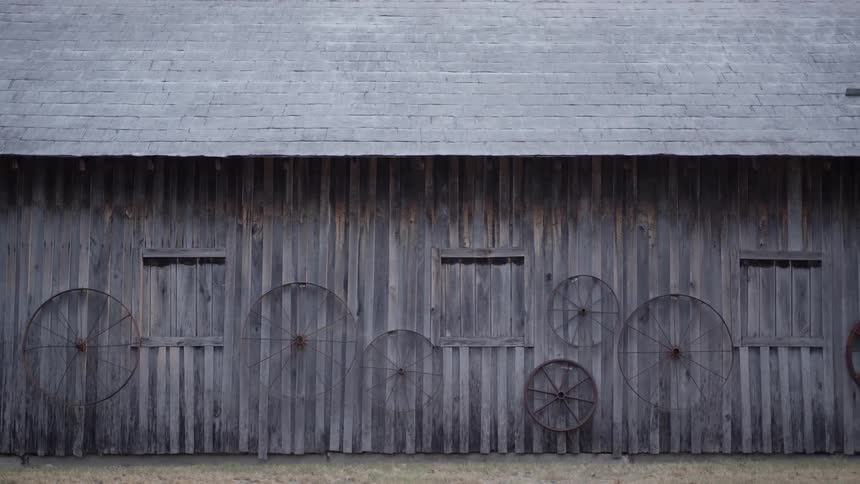A barn with wooden wheels nailed to it