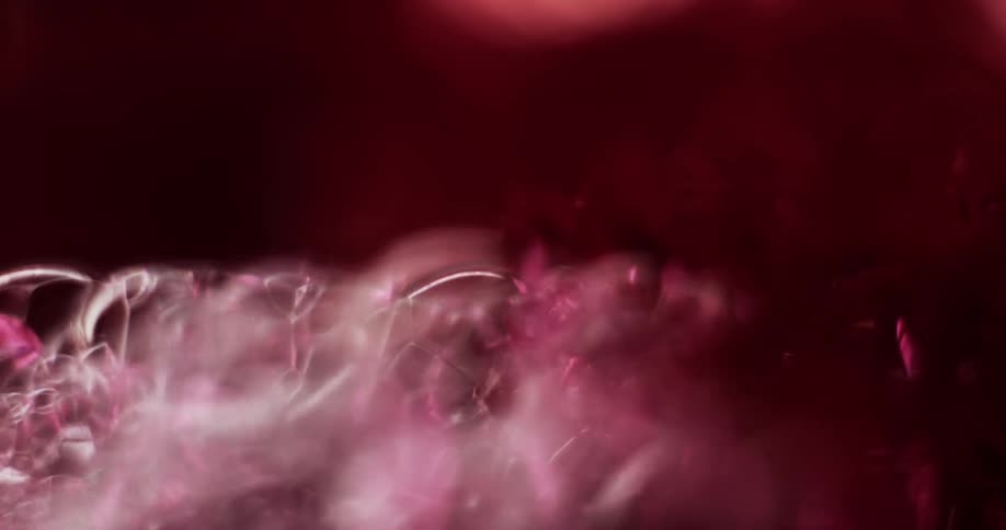 Crimson fluid bubbles up and foams