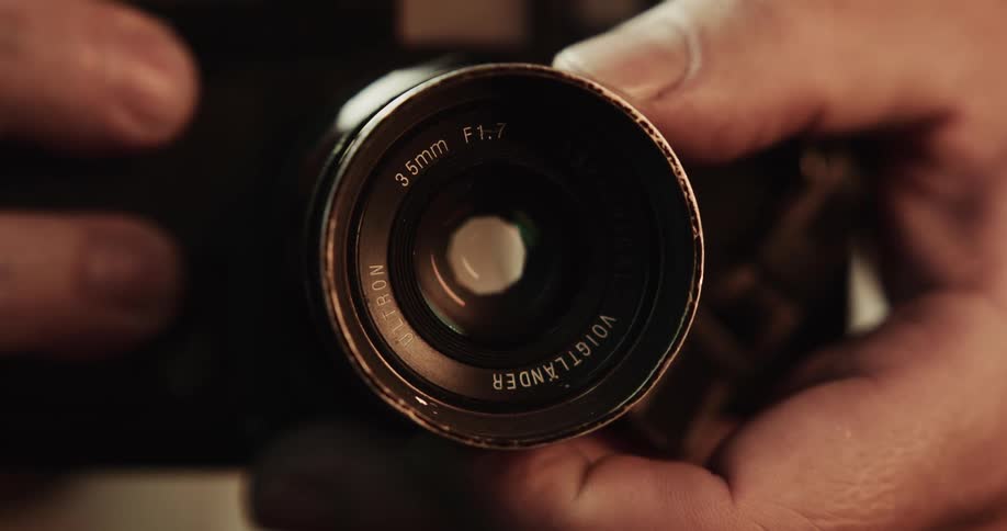 Close up of hand turning camera lenses
