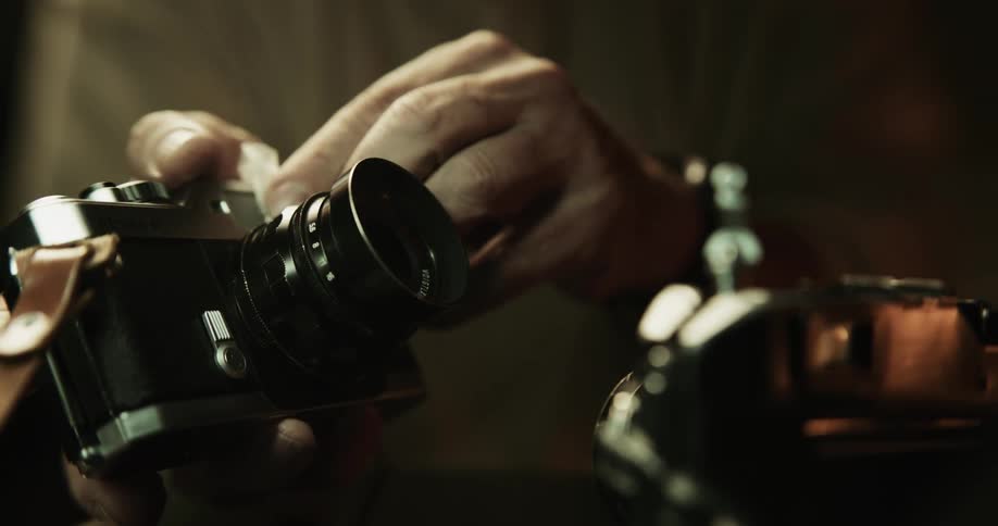 Close up of a photographer cleaning the lens of a vintage film camera