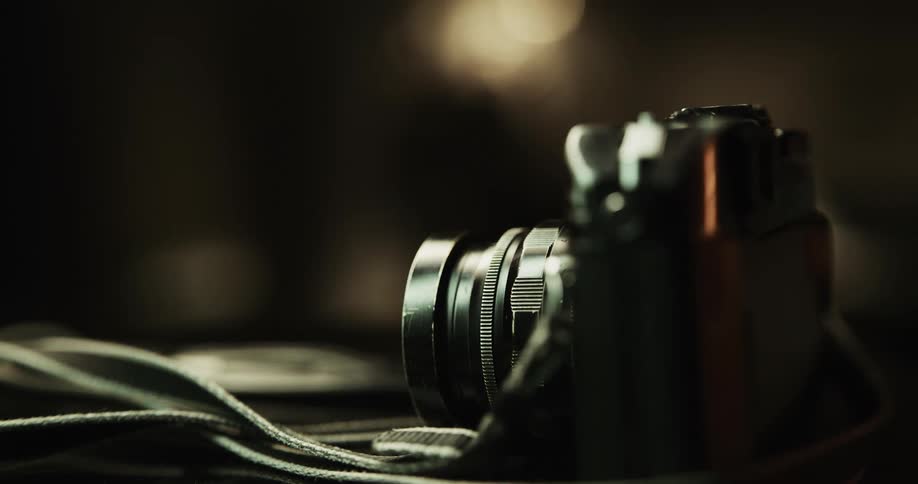 Male hands picking up a camera off a table