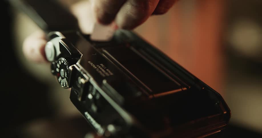 A man loading film into a camera