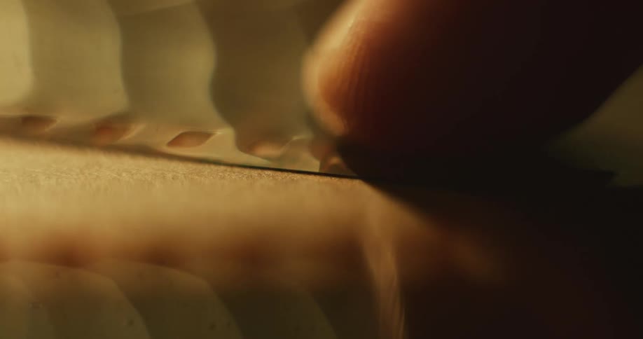 Closeup of mans finger adjusting photographic film