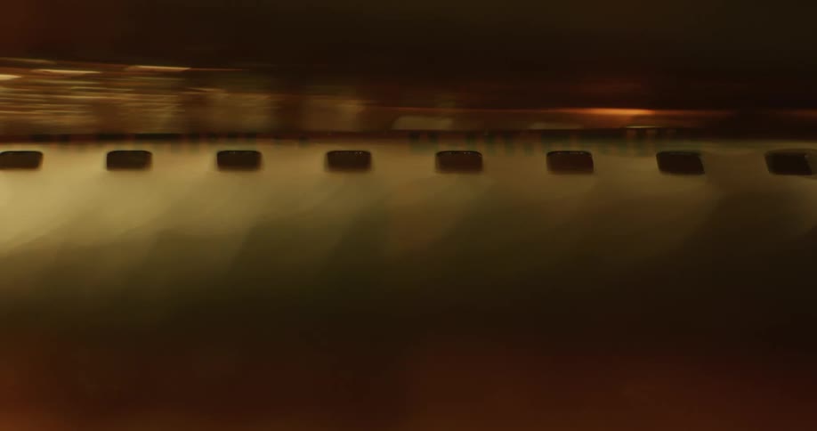 Light glares through film strips with perforated edges