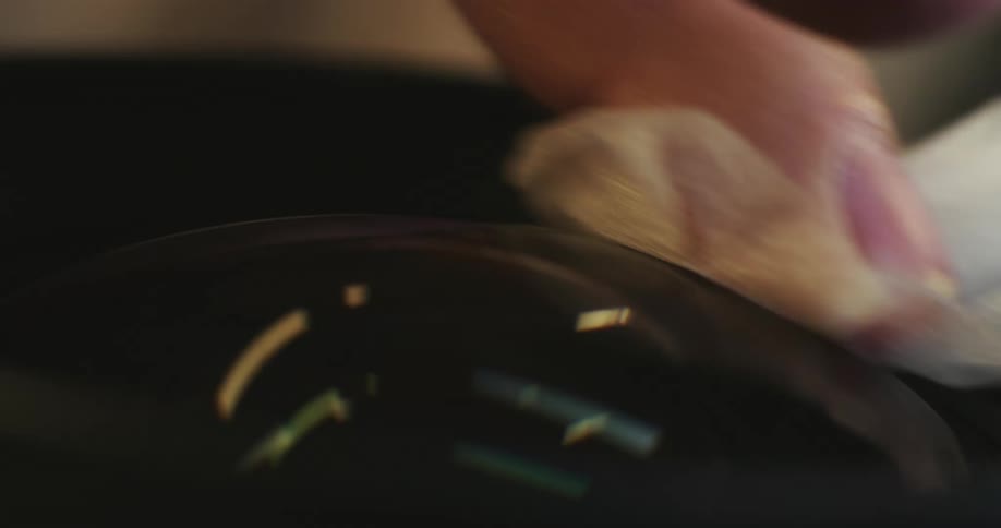 Person wipes lens glass with white cloth