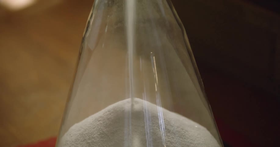 Hourglass flow of a sand from the upper bulb to the lower one