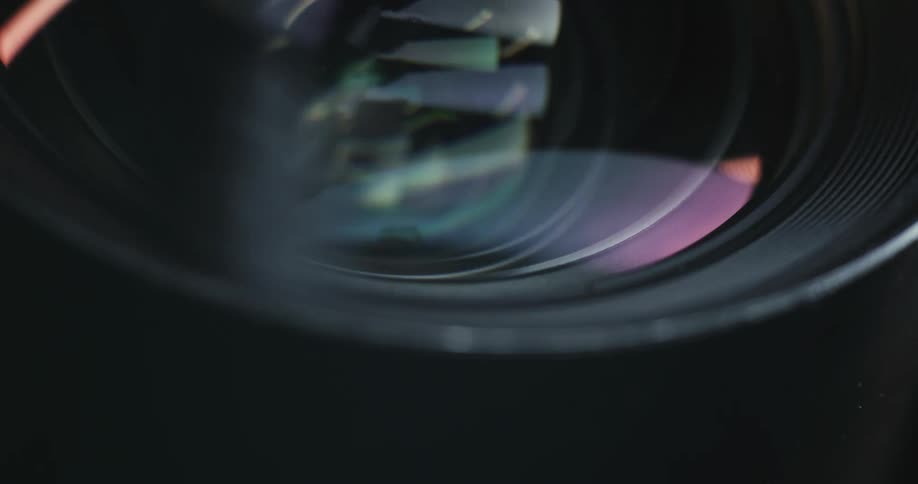 A man is cleaning a camera lens with a brush