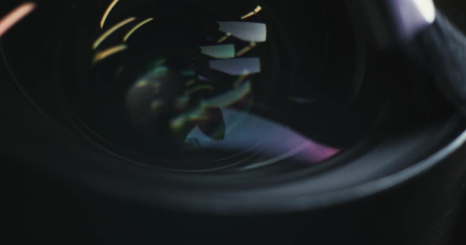 A person is cleaning the lens on a photography camera