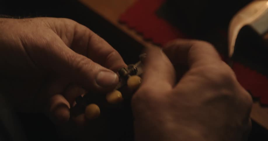 Luthier testing the pegs and tuners of a mandolin in his workshop