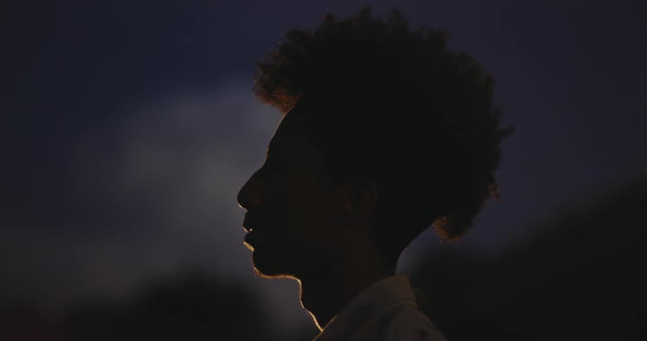 A man is standing in the dark at night