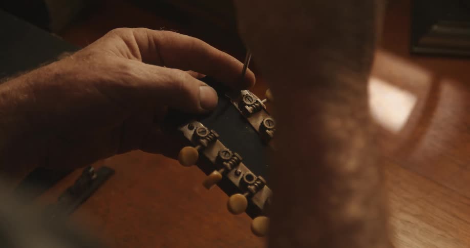 A man is fixing an instrument indoors by himself