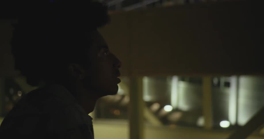 Side profile ofman with frizzy hair and denim jacket looking around