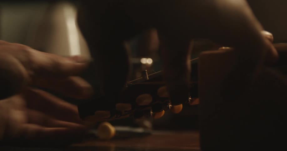 Close up view of a person fixing a guitar is displayed