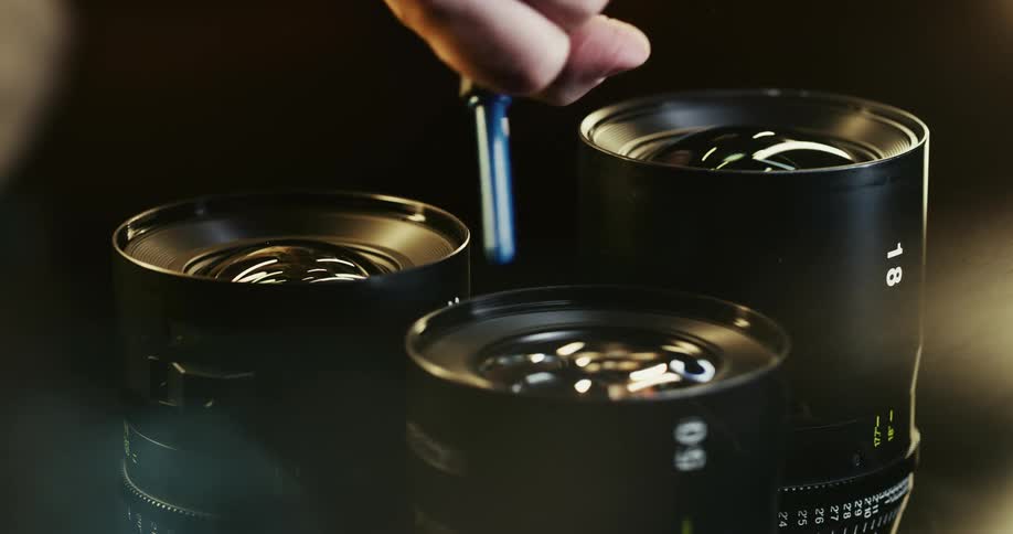 Close up of a man blowing air to clean camera lenses