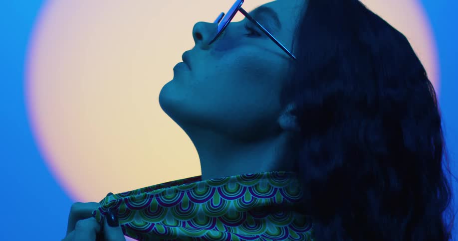 A woman is posing in a studio environment emulating a moonlit exterior