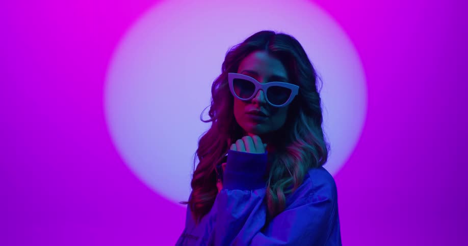 Portrait of a young woman standing in a purple studio environment