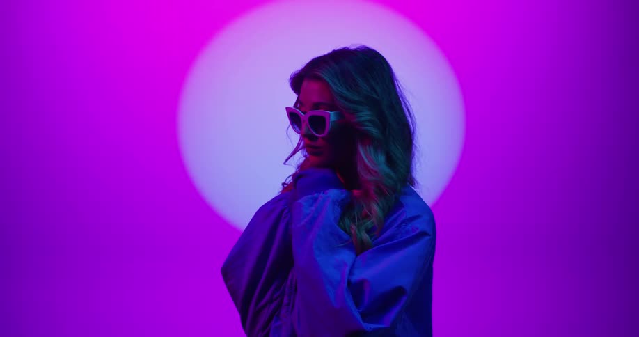 A woman is posing while wearing sunglasses