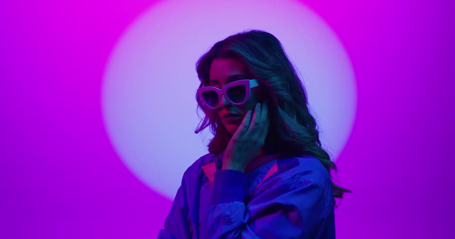 A woman is posing wearing sunglasses