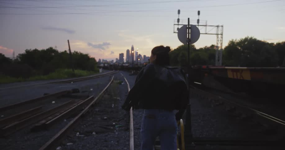A woman walking on train tracks