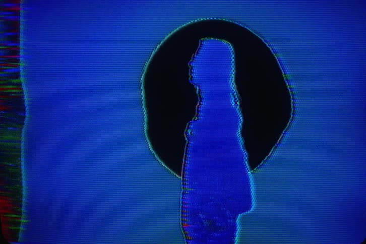 A woman is silhouetted as static on a screen
