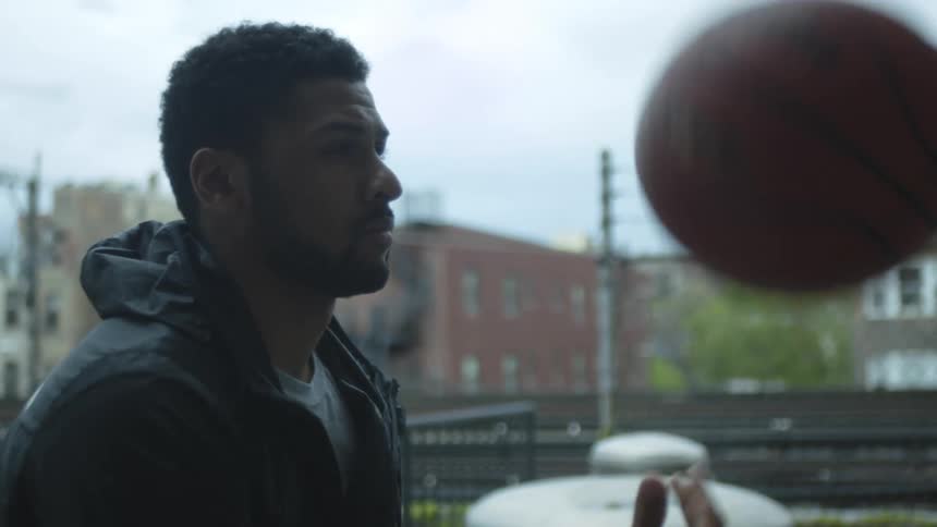 A man is tossing a basketball up and down