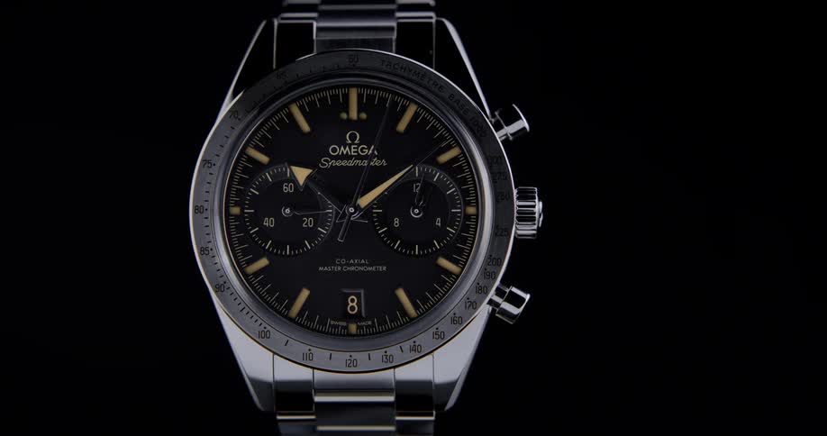 Close view of a silver analog watch face with a solid black background