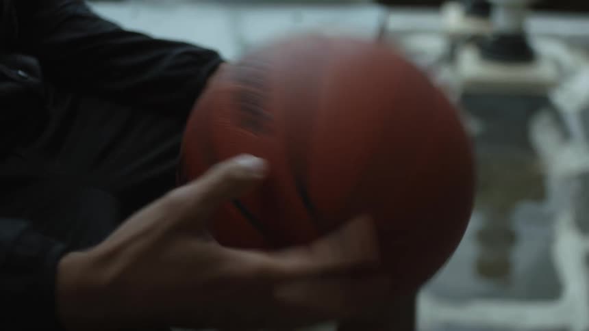 Person plays with basketball while sitting