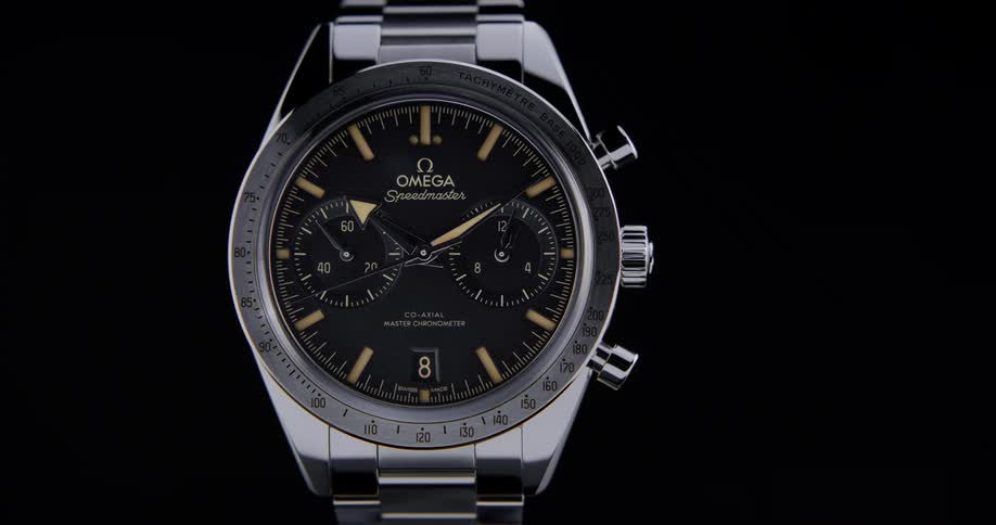 Close up of the dial of a luxury wristwatch against a black background