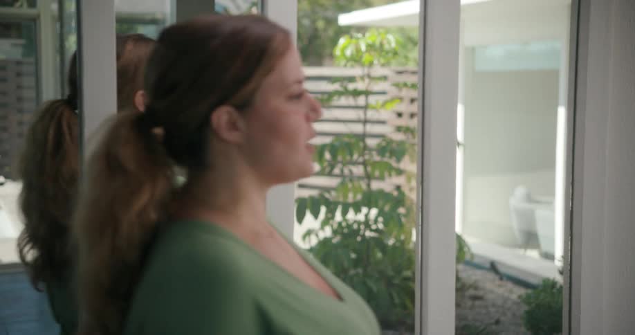 A woman paces back and forth in front of a mirror while rehearsing lines from a script