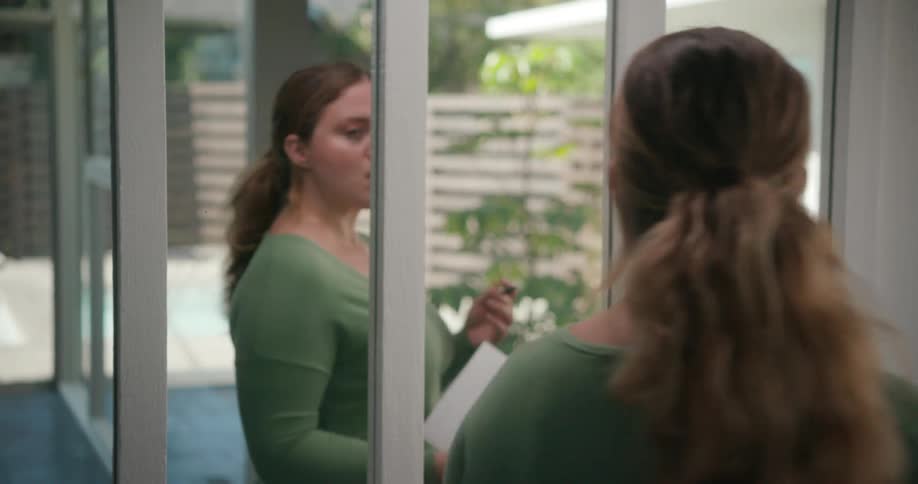 A woman pacing and practicing a speech in front of mirrors