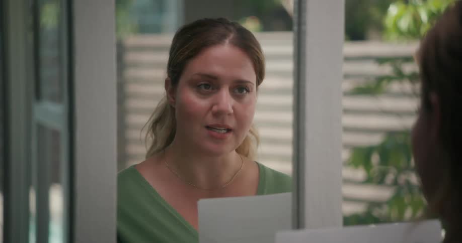 A woman looks into her mirror while rehearsing lines on her script